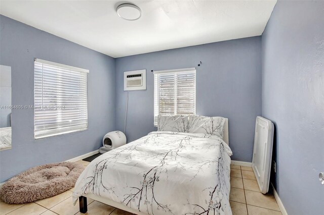 380 E 45th St, Hialeah, FL 33013 - bedroom featuring light tile patterned floors, a wall mounted air conditioner, baseboards, and radiator heating unit