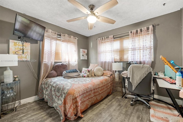 bedroom featuring a textured ceiling, wood-type flooring, and ceiling fan