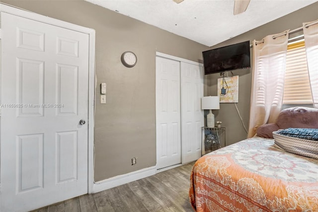 bedroom with hardwood / wood-style floors, ceiling fan, a closet, and a textured ceiling