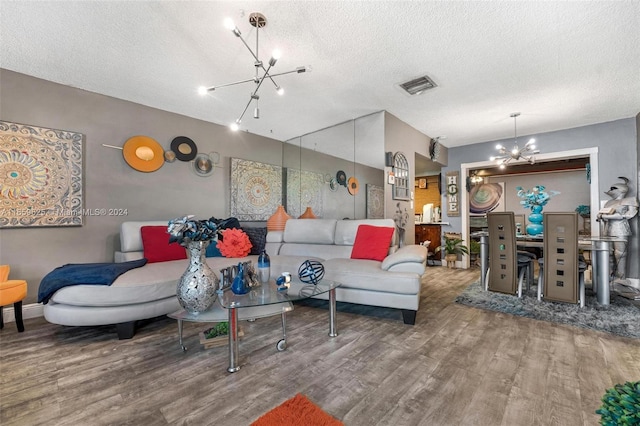 living room featuring a textured ceiling, hardwood / wood-style flooring, and a notable chandelier