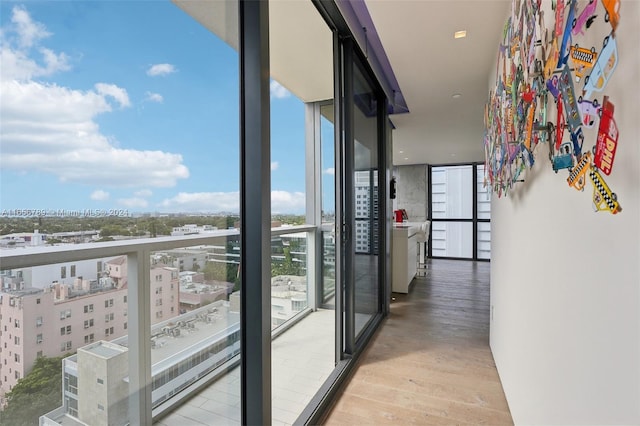 interior space with a wall of windows and light hardwood / wood-style floors