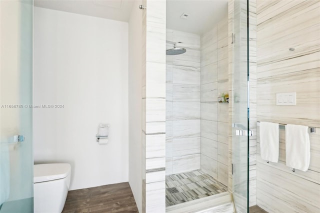 bathroom with toilet, hardwood / wood-style floors, and a shower with shower door