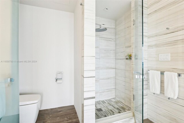 2201 Collins Ave Unit 1201, Miami Beach, FL 33139 - bathroom featuring a stall shower, wood finished floors, and toilet