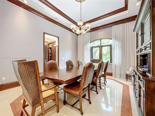 tiled dining area featuring ornamental molding, a tray ceiling, and a notable chandelier