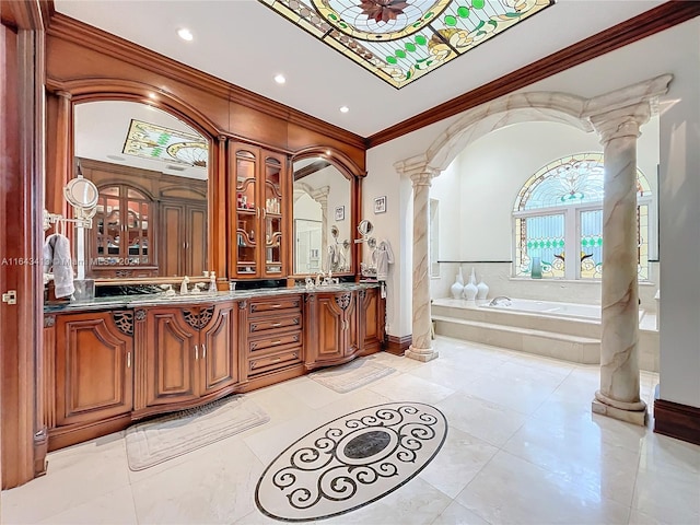 bathroom with tile patterned flooring, decorative columns, tiled bath, crown molding, and vanity