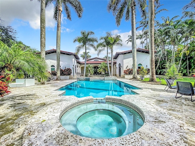 view of swimming pool featuring an in ground hot tub and a patio