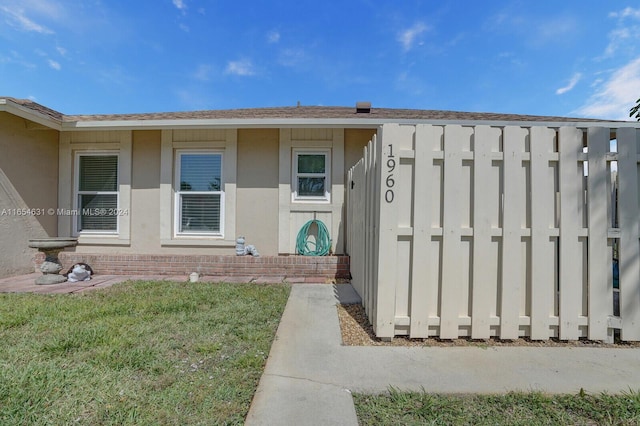 doorway to property with a lawn