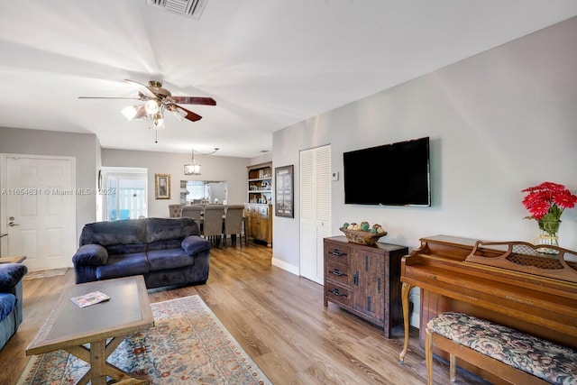 living room with ceiling fan and light hardwood / wood-style flooring