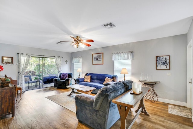 living room featuring wood-type flooring and ceiling fan