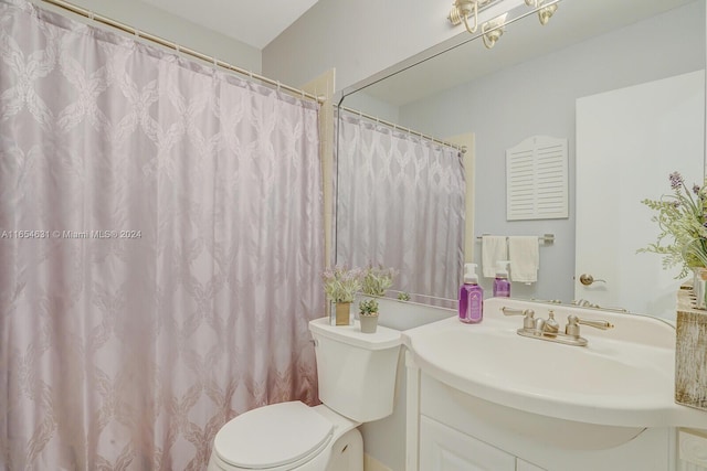 bathroom featuring toilet, vanity, and curtained shower