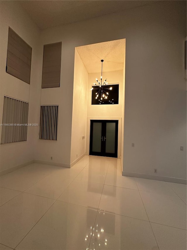 interior space with a towering ceiling, a textured ceiling, and an inviting chandelier