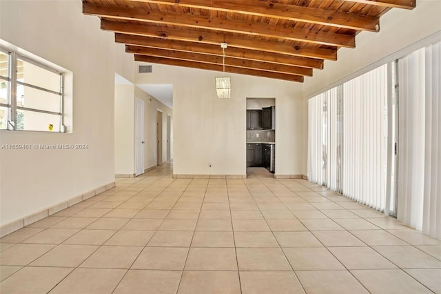 empty room with vaulted ceiling with beams, light tile patterned floors, and wooden ceiling