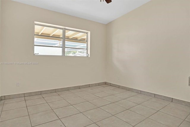 tiled spare room with ceiling fan