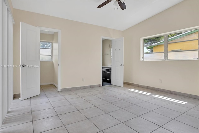 unfurnished bedroom with lofted ceiling, multiple windows, ceiling fan, and light tile patterned floors