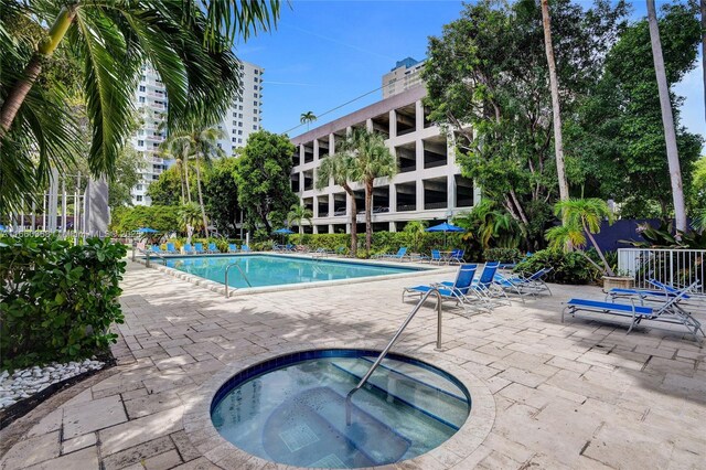 view of swimming pool with a community hot tub and a patio area