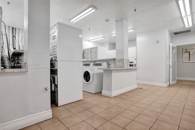 850 N Miami Ave Unit W-1810, Miami, FL 33136 - shared laundry area featuring stacked washer and clothes dryer, baseboards, and light tile patterned floors