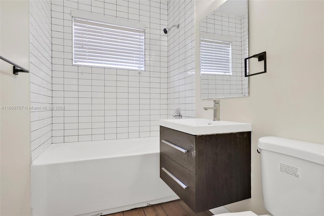 full bathroom with plenty of natural light, toilet, and hardwood / wood-style flooring