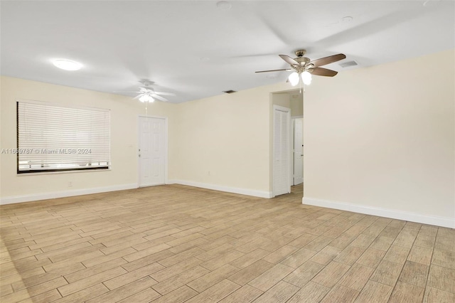 empty room with ceiling fan and light hardwood / wood-style flooring