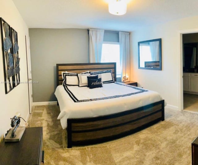 bedroom with connected bathroom and carpet floors