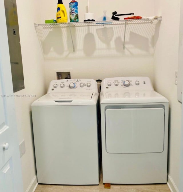 clothes washing area featuring washing machine and clothes dryer and electric panel