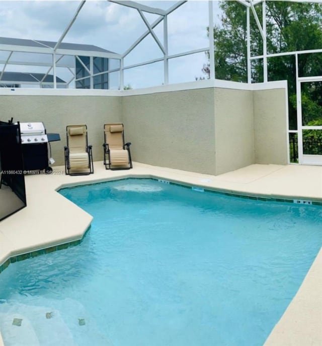 view of pool featuring glass enclosure