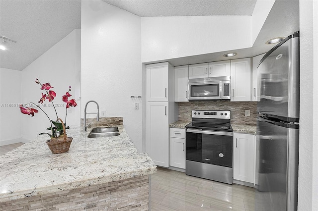 kitchen featuring sink, appliances with stainless steel finishes, a textured ceiling, and white cabinets