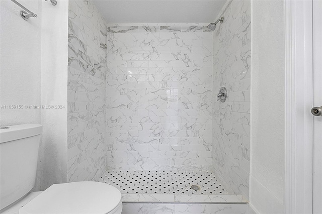 bathroom featuring toilet and tiled shower