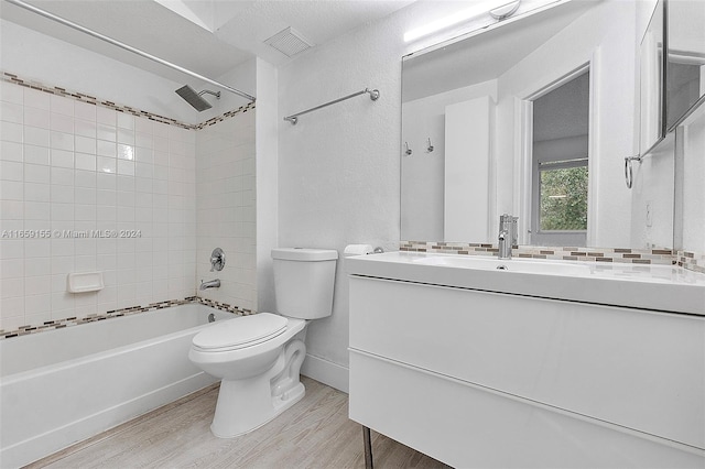 full bathroom featuring vanity, toilet, tiled shower / bath, and hardwood / wood-style floors