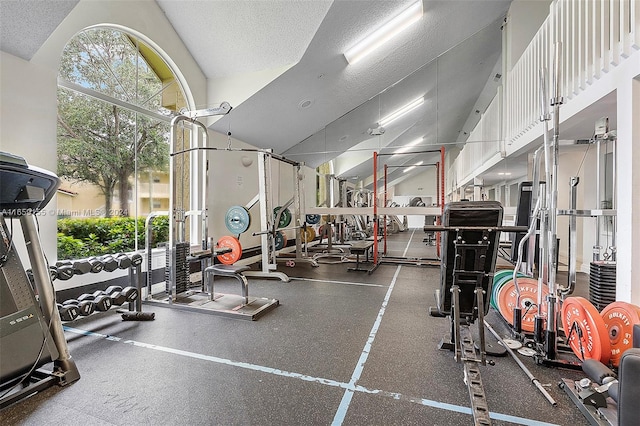 gym with a textured ceiling and lofted ceiling