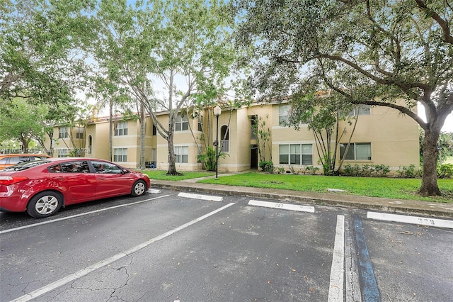 view of vehicle parking with a lawn