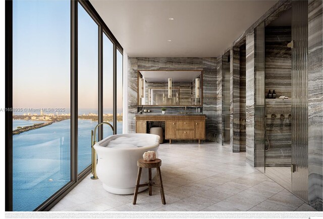 interior space with a healthy amount of sunlight, independent shower and bath, a water view, and vanity