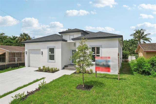 view of front of home with a garage, concrete driveway, a front yard, and stucco siding