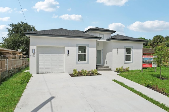 prairie-style house featuring a garage, fence, concrete driveway, and stucco siding