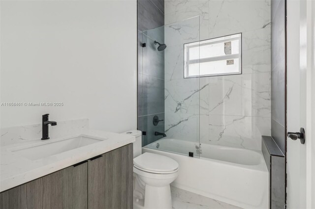 full bathroom featuring tiled shower / bath, vanity, and toilet