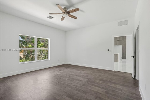 empty room with ceiling fan and dark hardwood / wood-style flooring