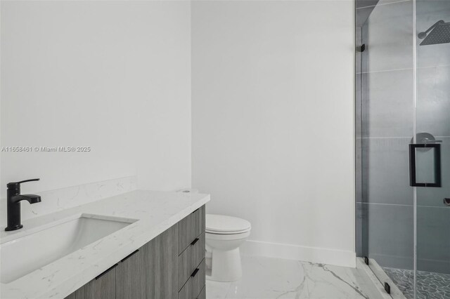 bathroom featuring vanity, a shower with shower door, and toilet