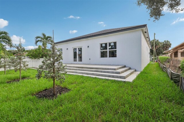 rear view of property featuring a lawn