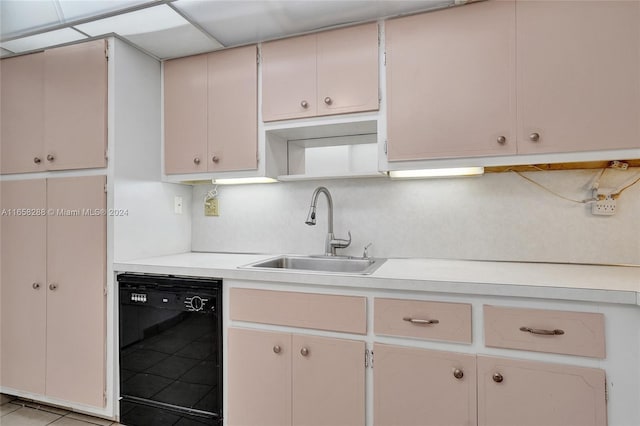 kitchen featuring light tile patterned floors, black dishwasher, a paneled ceiling, and sink