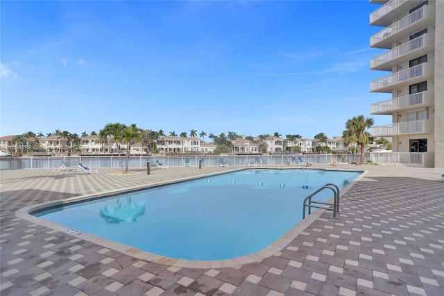 view of swimming pool with a patio and a water view