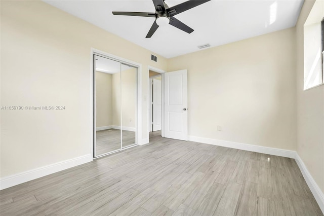 unfurnished bedroom with light hardwood / wood-style flooring, ceiling fan, and a closet