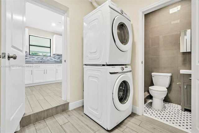 laundry room with stacked washer / dryer and sink