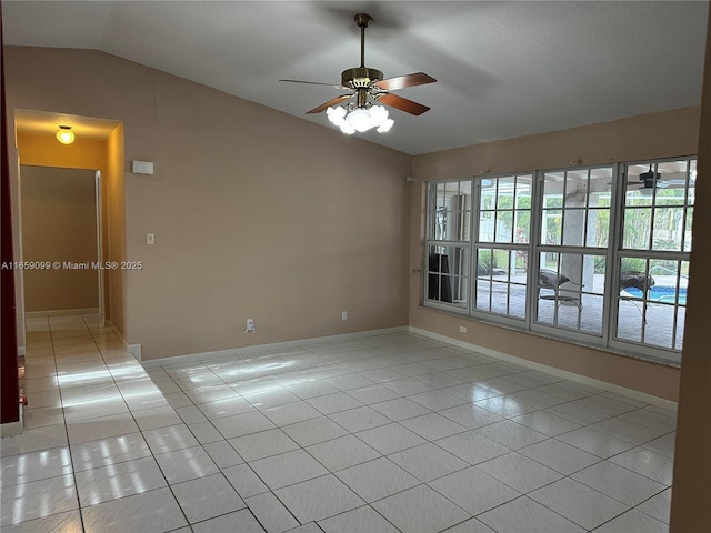 spare room with light tile patterned floors, vaulted ceiling, and ceiling fan