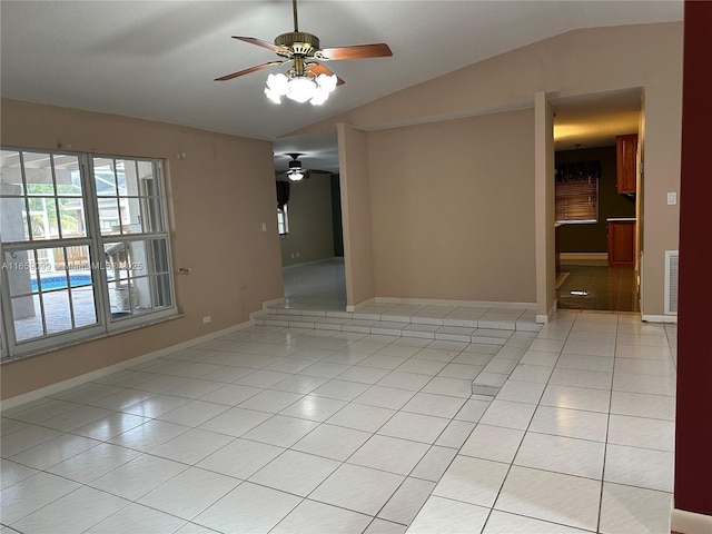 tiled empty room featuring ceiling fan and vaulted ceiling