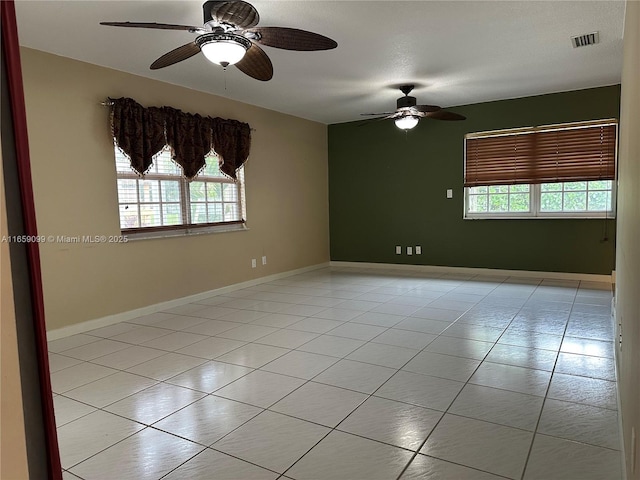 tiled spare room featuring ceiling fan