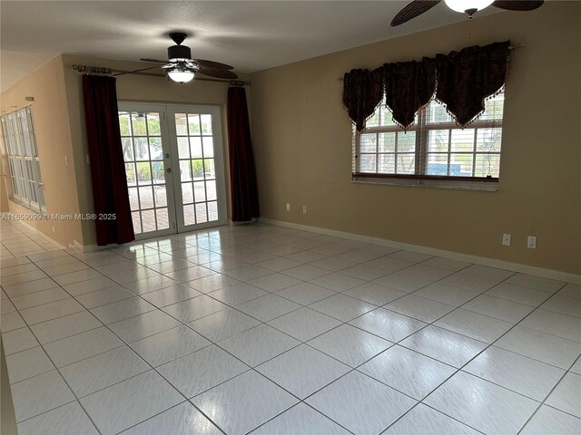 tiled spare room featuring french doors and ceiling fan