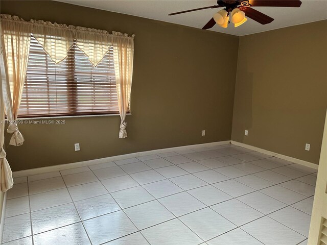 empty room with light tile patterned floors and ceiling fan