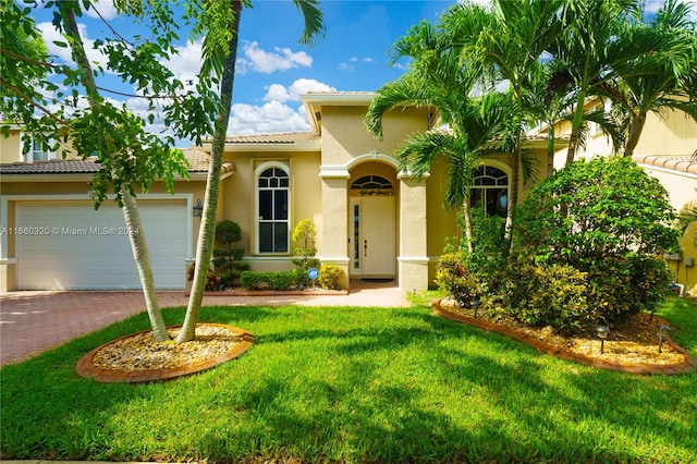 mediterranean / spanish house featuring a garage and a front yard