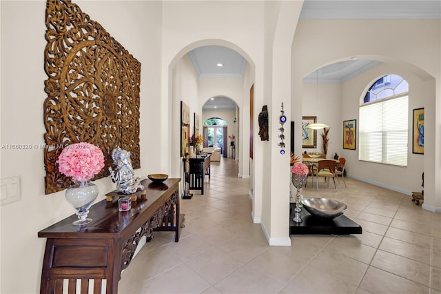 hallway featuring light tile patterned floors and crown molding