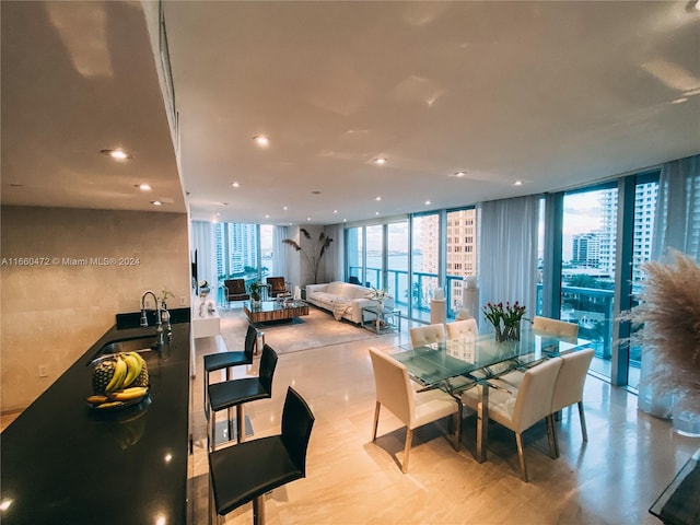 dining space with a healthy amount of sunlight, floor to ceiling windows, and sink