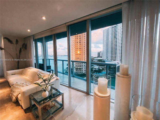 living room featuring a water view, a wall of windows, and plenty of natural light